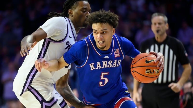 Kansas guard Zeke Mayo (5) drives around Kansas State guard C.J. Jones, left, during the first...