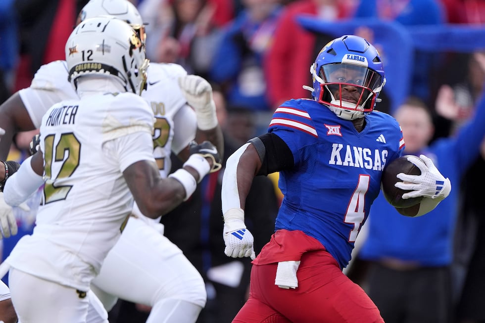 Kansas running back Devin Neal (4) is chased by Colorado cornerback Travis Hunter (12) to...